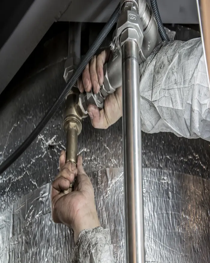 Plumber at work under a sink