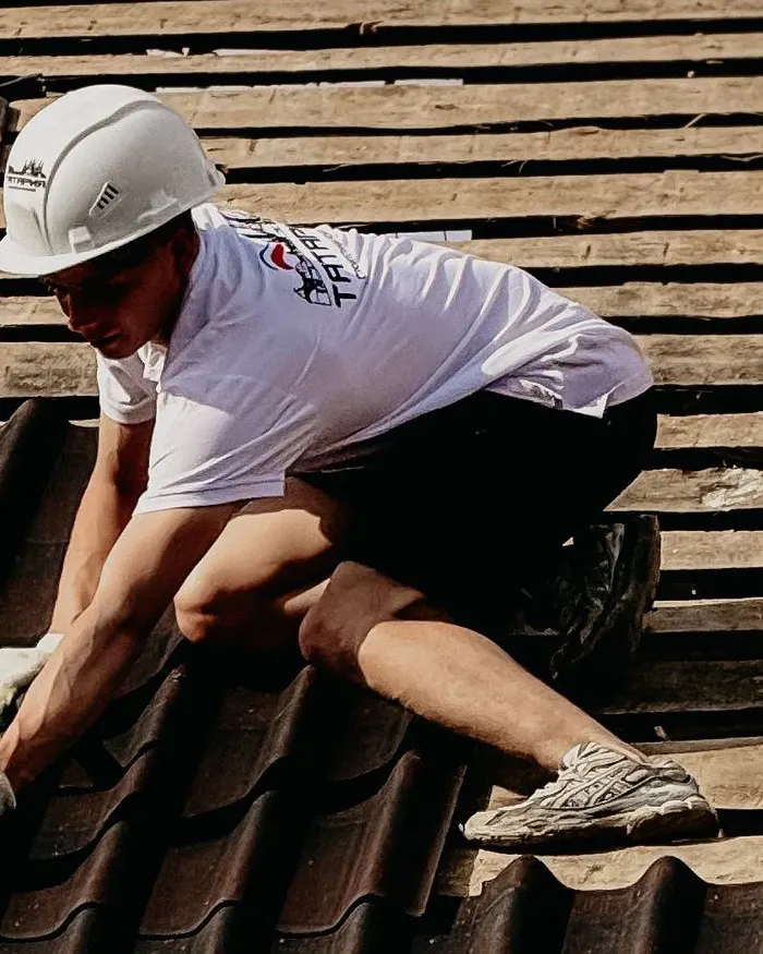 Roofer installing shingles